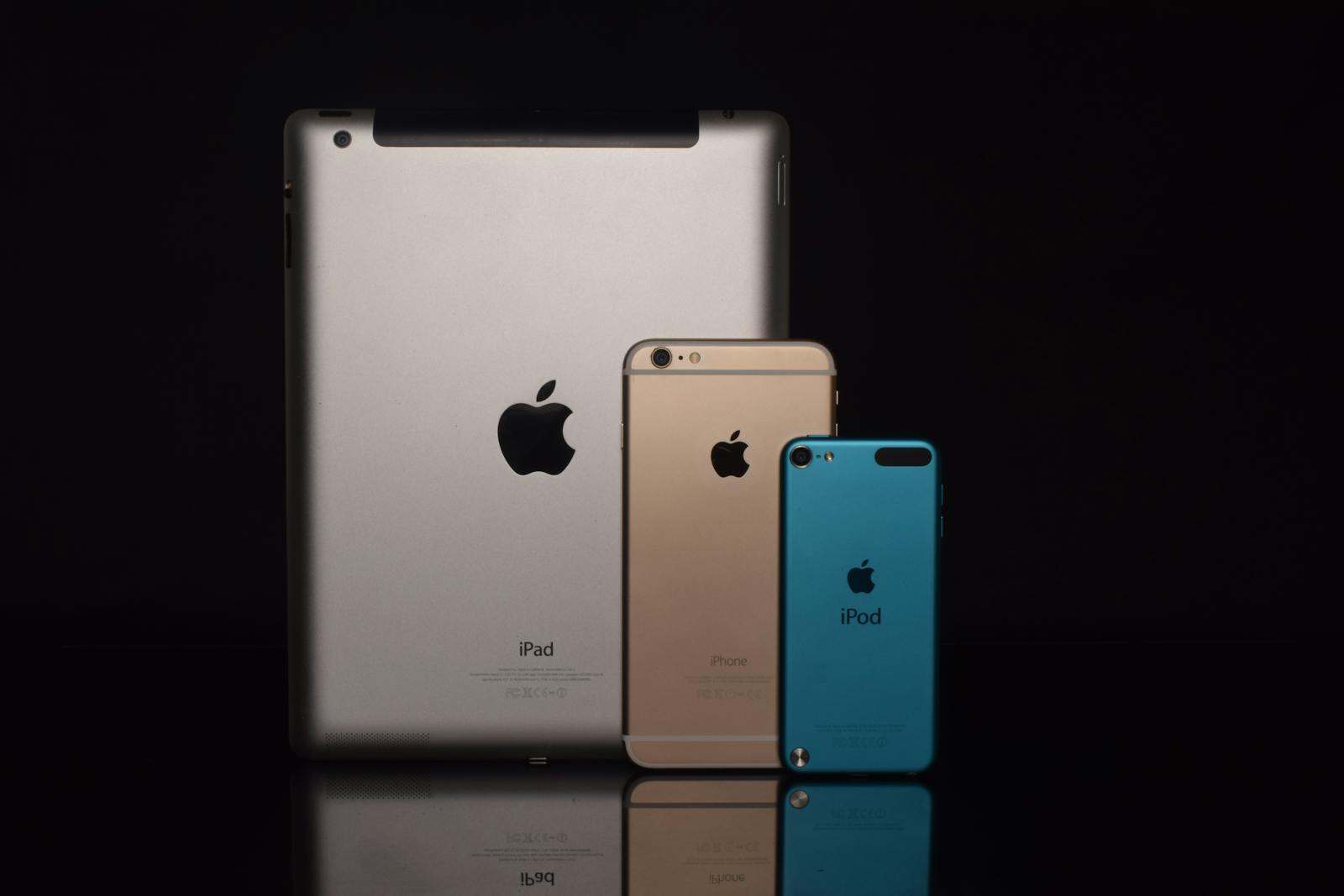 Elegant display of Apple devices including iPad, iPhone, and iPod against a black background.